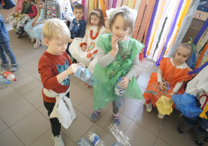 Dziewczynka i chłopiec odkręcają plastikowe butelki